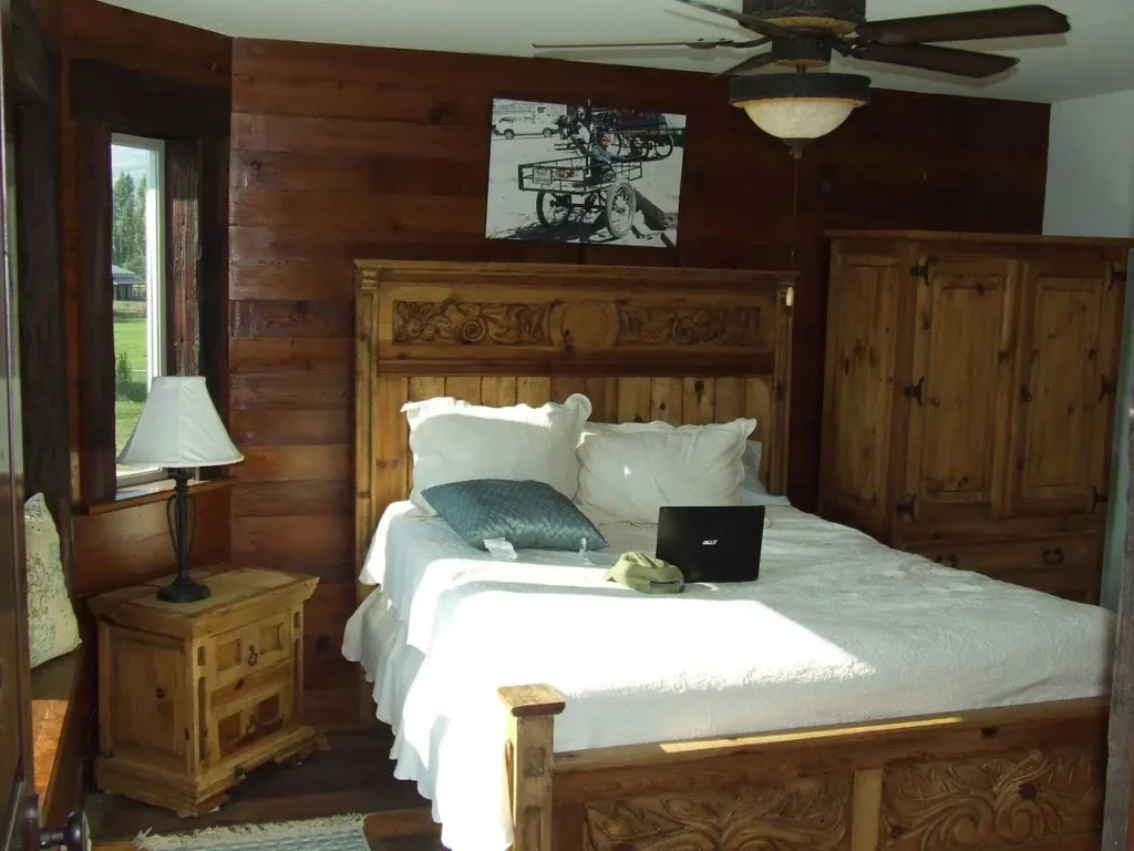image shows a bedroom with wooden furniture and paneling
